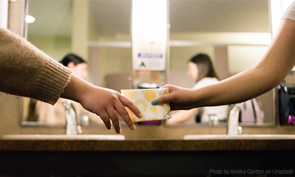 young girl taking sanitary pad from a woman during periods